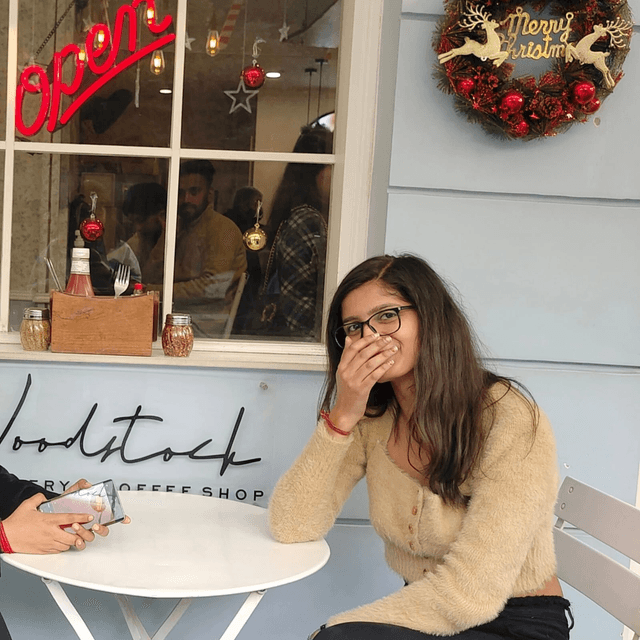 laughing outside a christmas-decked coffee shop